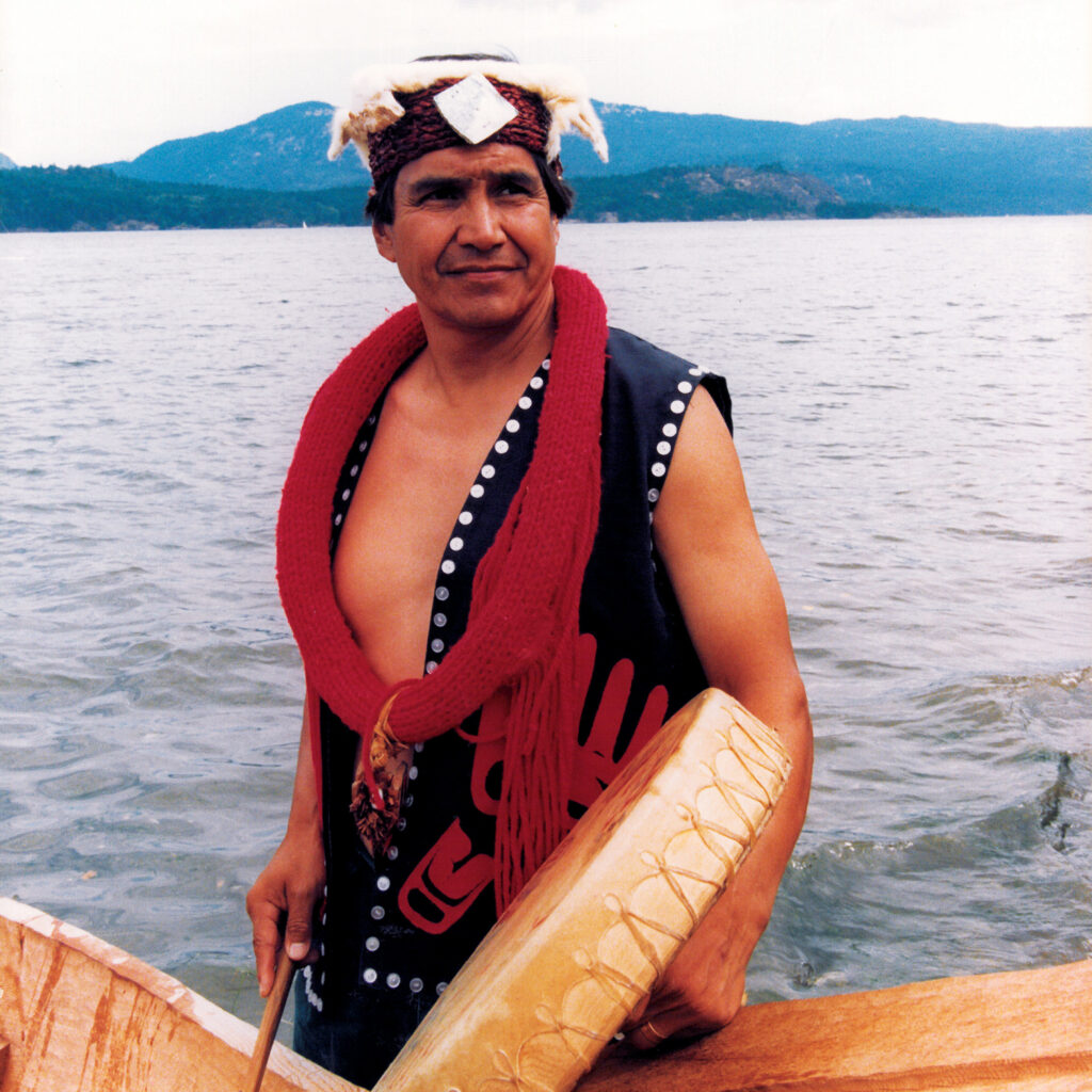 Alex Nelson holding a drum in traditional clothing