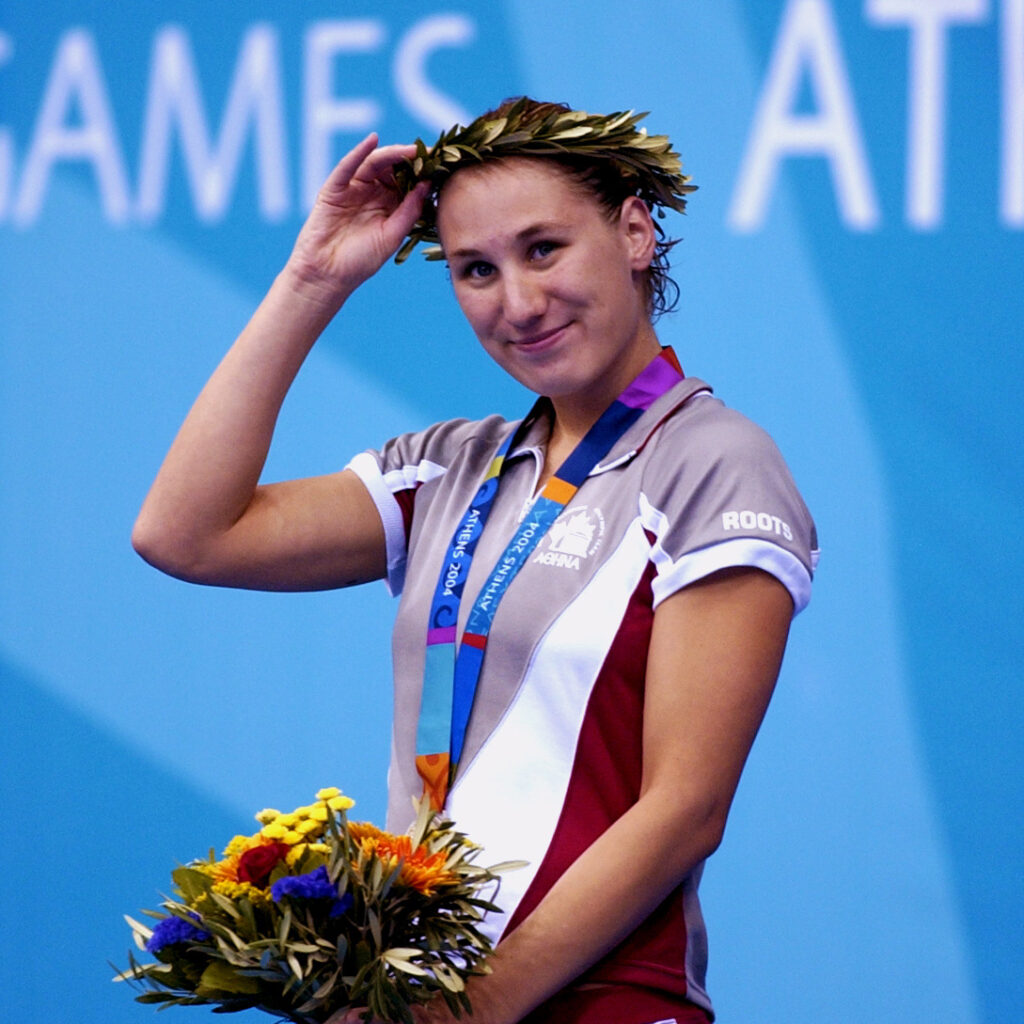 Kirby Cote holding a bouquet of flowers with her Paralympic Silver Medal around her neck at the Athens 2004 Olympic Games